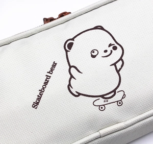 Close-up of durable white canvas fabric with skateboard bear print and metal zipper