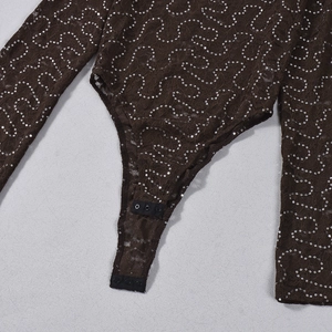 Detail of the warm brown lace bodysuit featuring silver sequins and three bottom snap buttons