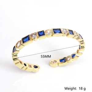 Detail of gold-plated cuff bracelet with blue rectangle gems and clear zircon accents