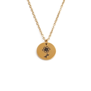 Detailed close-up of a golden circular pendant necklace featuring an engraved flower design