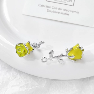 Detail shot of two yellow rose pendants with silver leaves for DIY jewelry making