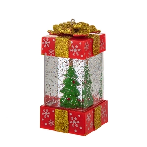Light-up Christmas gift box lantern with snowy trees and gold ribbon on white background