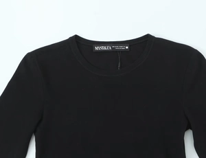 Détail du t-shirt noir à manches longues montrant l'encolure et l'étiquette