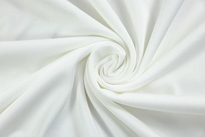 Macro detail of soft white knit fabric texture and elegant spiral draped folds