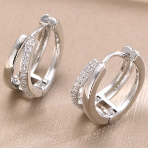 Macro shot of silver double-hoop earrings featuring micro-pave set sparkling zircon stones