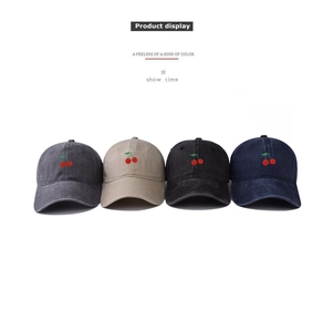 Close-up of four washed cotton baseball caps with cherry embroidery in multiple colors