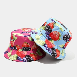 Detail view of pink and blue bucket hats with vibrant strawberry and blueberry fruit prints