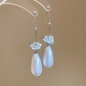 Détails de boucles d'oreilles fleur argentée avec pavé de zircons et perles en goutte