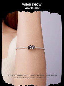 Wrist view of a 925 sterling silver mesh bracelet featuring a purple gothic bat charm