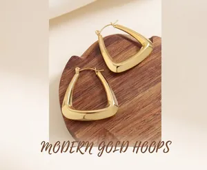Close-up of gold-plated U-shaped earrings on wood, showing polished geometric texture