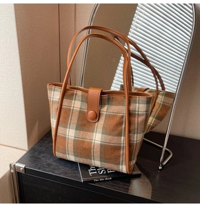 Brown checkered woolen tote bag with leather handles shown in a lifestyle mirror setting