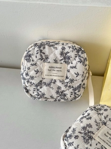 Quilted floral sanitary napkin storage bag in cream cotton with black flower pattern
