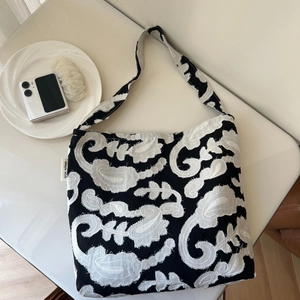 Minimalist black and white paisley embroidered cotton shoulder bag with textured finish