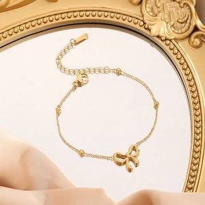 Détail du bracelet noeud doré avec perles rondes et chaîne d'extension réglable