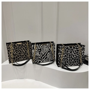 Chic tote bags in leopard and zebra prints featuring elegant gold metal bars and chain straps