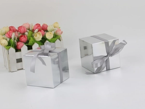 Silver square mirror gift boxes featuring grey ribbon bows on a clean white surface