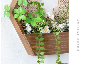 Detalle de jardinera de pared hexagonal de madera con plantas y diseño de celosía