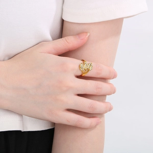 Detail shot of a luxury gold-plated hollow leaf ring with sparkling crystals on a hand