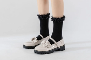 Détail de chaussures Mary Jane blanches avec nœuds et chaussettes lolita en dentelle
