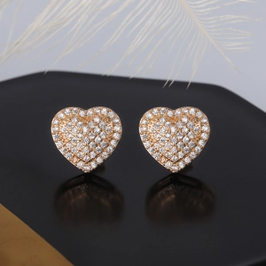 Macro detail of gold heart earrings with pavé cubic zirconia on black mirror reflection
