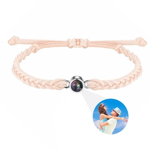Detailed view of pink woven bracelet featuring custom photo projection stone for couples