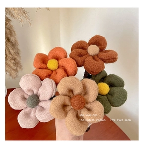 Detail view of five assorted colors handmade felt flower hair clips for autumn winter