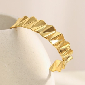 Détail d'un bracelet jonc géométrique plaqué or 18K avec motifs ondulés