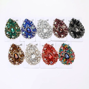 Macro view of crystal teardrop brooches in various colors for elegant dress decoration