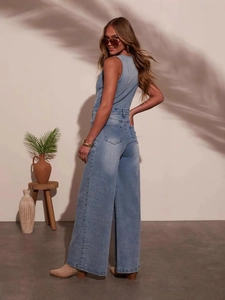 Détail d'une combinaison en jean bleu clair sans manches à jambes larges et passants