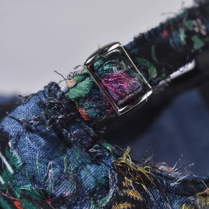 Macro detail of adjustable silver buckle and colorful lace fabric on a baseball cap
