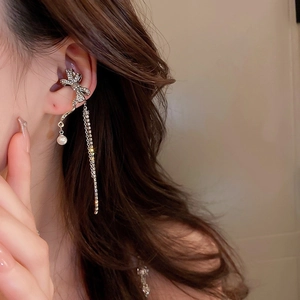 Close-up of silver butterfly tassel ear cuff with sparkling zircons and delicate pearls