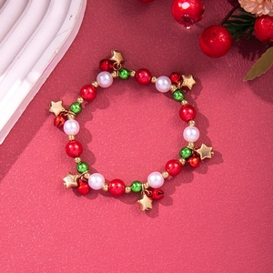 Detailed view of Christmas charm bracelet with festive red and green beads and gold bells