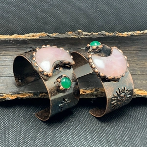 Details der Vintage-Bronze-Armreifen mit geprägten Sonnenmustern und eingelegten Edelsteinen