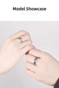 Detail of astronaut couple rings with blue star stone and star engravings on fingers