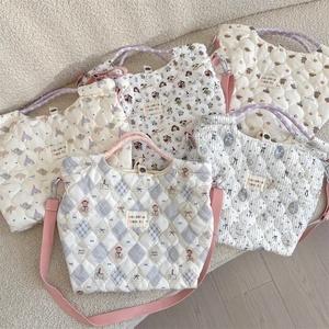 Gros plan de sacs en coton matelassé avec imprimés cartoon et anses tissées colorées