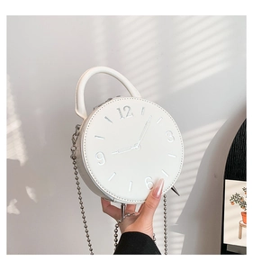 Détail du sac à main rond blanc en forme d'horloge avec chiffres argentés et chaîne chic