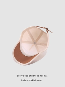 Detail of child baseball cap interior with leather strap and metal buckle adjustment