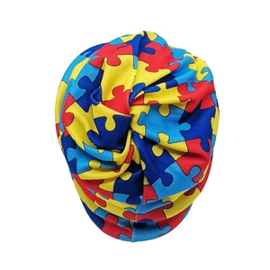 Detail of colorful geometric puzzle print on stretchy knot turban hat for outdoor use