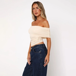 Detailed close-up of cream off-the-shoulder mesh top with ruched texture and cropped fit