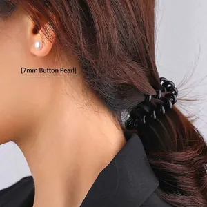 Classic 7mm white freshwater pearl stud earring worn by a model for a minimalist look