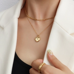 Collier double couche doré avec pendentif cœur et bague large texturée en parure