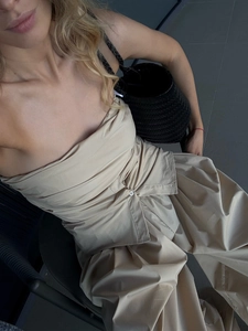 Detail of beige cotton bloomers pants with wrap top and woven leather handbag