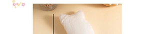 Detail of soft white plush cat-shaped pencil case with cute 3D ears on cream background