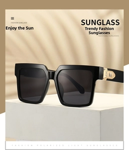 Detail of golden metal hinge with M logo on stylish black oversized square sunglasses