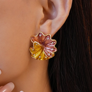 Close-up of large floral stud earrings with gradient enamel, ruffles and crystal center