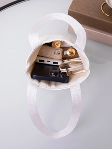 Internal view of a small white quilted tote bag showing its spacious storage for gadgets