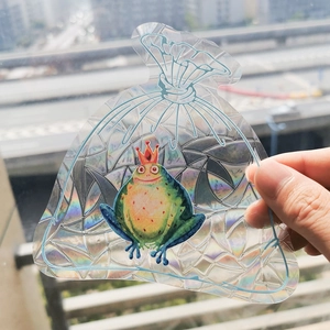 Rainbow suncatcher window sticker featuring a cute frog with crown and holographic texture