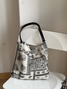 Detailed view of bohemian printed linen tote bag featuring premium black leather handles