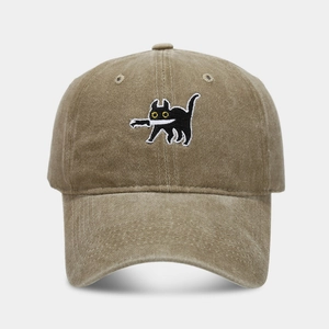 Close-up of a khaki washed cotton baseball cap with a black cat holding a knife embroidery