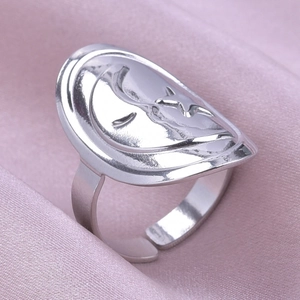 Gros plan sur bague argentée avec lune et étoile en relief sur soie rose, taille réglable